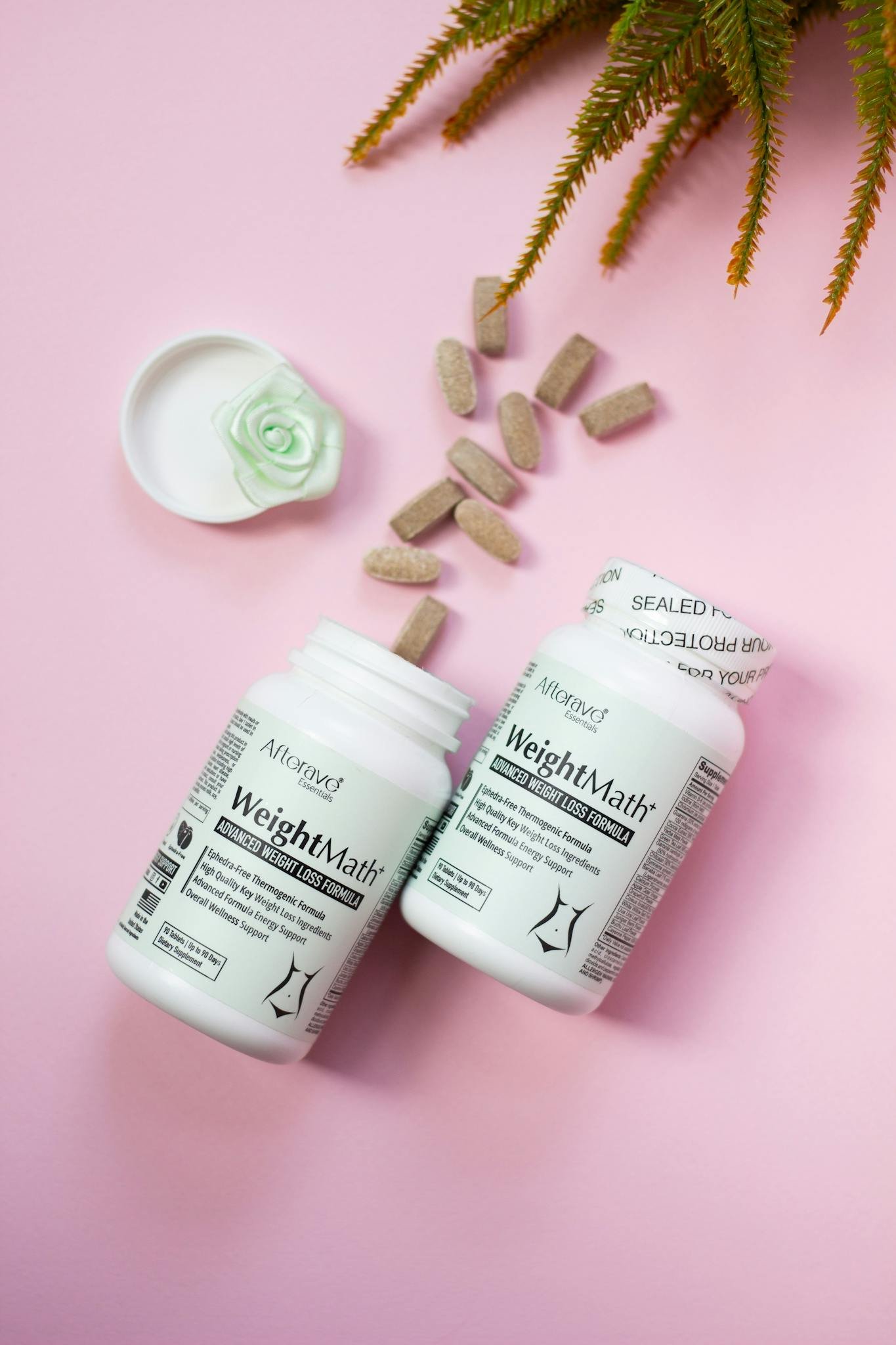 Two bottles of weight loss supplements with pills on a pink background.